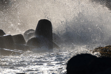 Sea waves reach tetrapods in the breakwater system and is splahsed everywhere