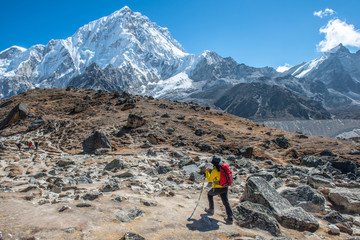 Tourist woman during trekking to Everest Base Camp with beautiful view of Mt.Nuptse (7,861 metres) in Sagarmatha national park, Nepal. Conceptual of tourist trekking in Nepal. - obrazy, fototapety, plakaty