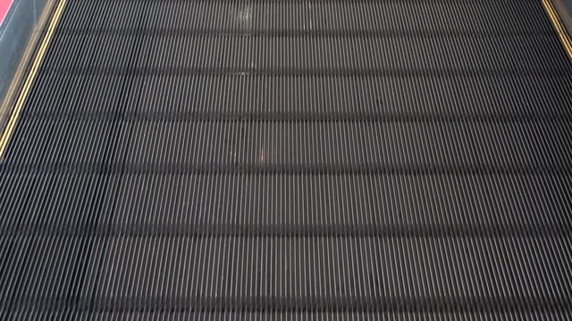 Moving walkway, moving sidewalk, moving pavement, travelator, horizontal escalator, moveator, or auto walk at an international airport terminal, in modern office centre