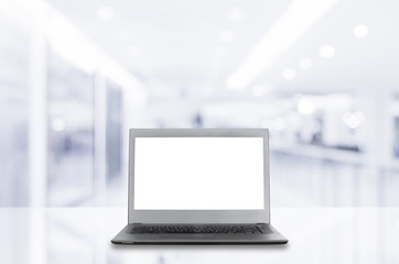laptop computer blank white screen open front display on white table with blur room indoor background with reflection. technology mockup device black and grey color.
