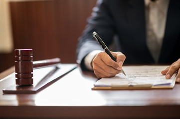 The lawyer is carrying a pen to write a case record in the courtroom