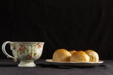 Traditional chinese cake on a plate with a cup of tea.
