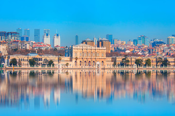 Dolmabahce Palace (Dolmabahce Sarayi) seen from the Bosphorus - Dolmabahce palace against coastal cityscape with modern buildings - Istanbul, Turkey