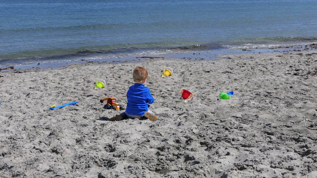 Child Playing With Bucket And Spade While Social Distancing On A Beach In UK