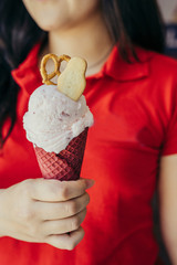 Woman in red t-shurt holding a red velvet ice cream cone with pr