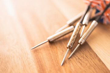 Darts on a wooden table close-up. Wooden background.