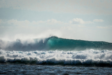 A huge wave for surfing . The photo was taken from the water in the Indian Ocean island of Mauritius