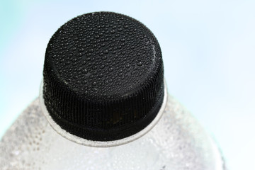 Close-up of plastic bottle, mineral water, bright background view