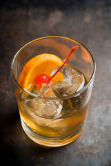 Old fashioned beverage with orange slices on rustic background. Selective focus. Shallow depth of field.