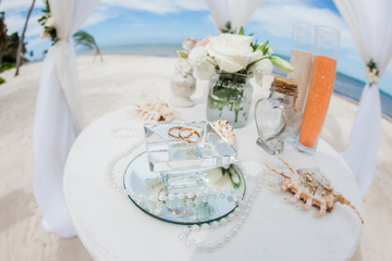 Wedding rings close up decorated nautical with accessories for tropical caribbean outdoor wedding ceremony on the sandy beach in Dominican republic, Punta Cana