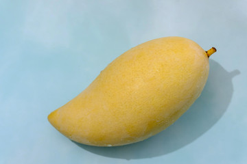 Fresh mango fruit on light blue background with copy space