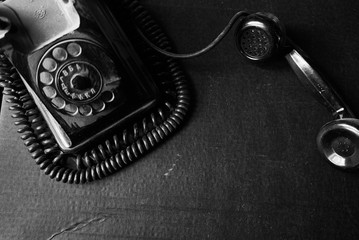 vintage black old rotary telephone handset on black background - obrazy, fototapety, plakaty