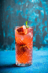 Red cocktail with blood oranges and thyme on the rustic background. Selective focus. Shallow depth of field.