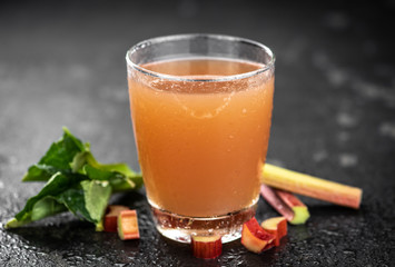Rhubarb Juice on rustic background (close up; selective focus)