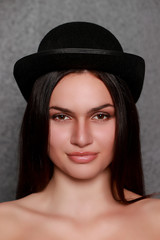 Portrait d'une jeune femme brune avec un chapeau melon