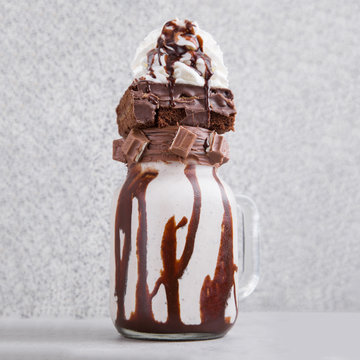 Milkshake With Whipped Cream, Brownie, Chocolate Bar And Sauce