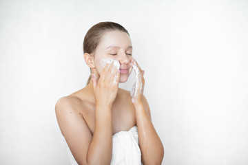 A beautiful caucasian woman washes her skin on her face and smiles. Happy healthy woman. Skin care....