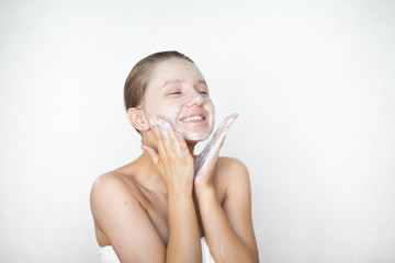 A beautiful caucasian woman washes her skin on her face and smiles. The concept of personal care....