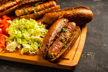 Tasty fresh hot dogs with grilled sausage on the rustic background. Selective focus. Shallow depth of field.