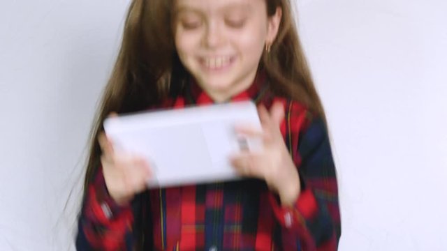A Little Girl in Plays with a Tablet Computer, Children's Dependence on Gadgets