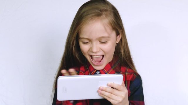 A Little Girl in Plays with a Tablet Computer, Children's Dependence on Gadgets