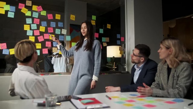 Creative Business Team Brainstorming Ideas Working Together Near Glass Wall With Sticky Notes. Colleagues approve. Business Success Concept