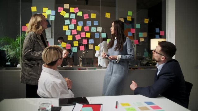 Creative Business Team Brainstorming Ideas Working Together Near Glass Wall With Sticky Notes. Colleagues approve. Business Success Concept