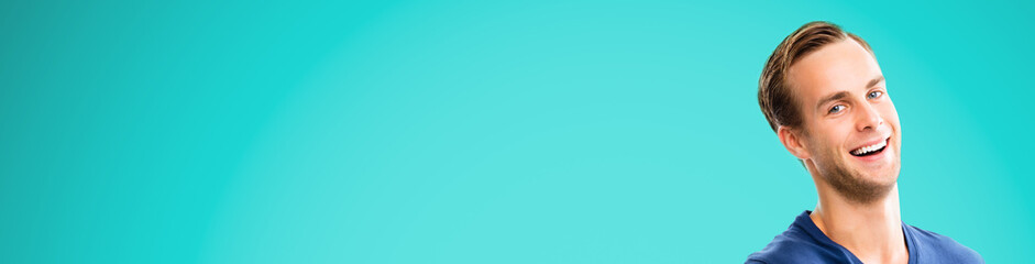 Fototapeta premium Face portrait - very happy man over aqua marine blue color background. Excited male model with open mouth, in smart casual wear at studio picture. Wide horizontal banner composition. Copy space area.