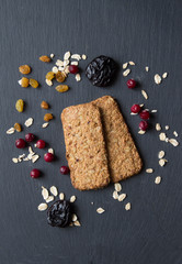Oatmeal cranberry cookies on a stone surface with rolled oat cerealdried, fresh cranberries, prunes. Top view.