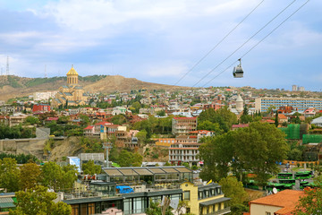 Fototapeta premium The Scenery of Aerial Cable Car from Downtown Tbilisi to Narikala Fortress with Sameba Cathedral in Afar, Tbilisi, Georgia