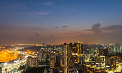 Fototapeta premium Views of Singapore during the night after sunset. The lights from the city's high buildings, ports and roads and beautiful skies in cityscape concept.
