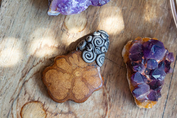Beautiful ayhuasca root pendant on wooden backround with amethyst druses