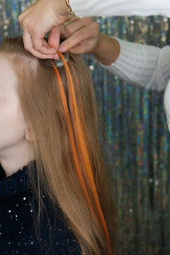 Capsule hair extensions in professional beauty salon. Process of hair extensions. Colored strands. Background