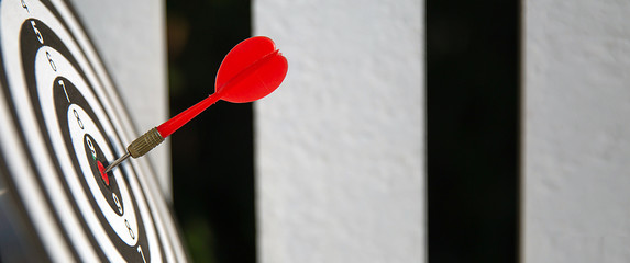 Bullseye or dart board has dart arrow throw hitting the center of a shooting target for business...