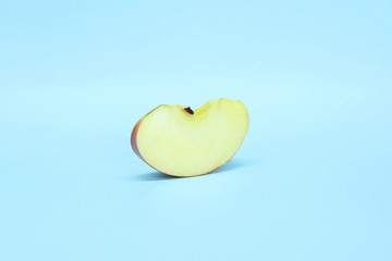 Slice a juicy fresh apple on a blue background. Delicious sliced fruit.