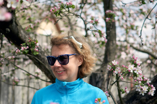 Sporty Middle Aged Smiling Woman In Spring Blossom Tree. Peaceful Mindful Mature Senior Grandmother Relaxing Outdors.