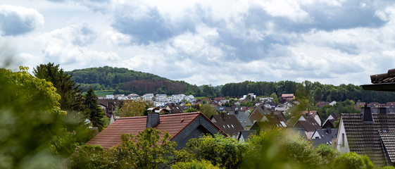 view over a village, rooftops, hills in the background