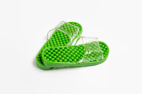 Green rubber slippers on a white background.Rubber slippers. Foot treatment. High-resolution photo.