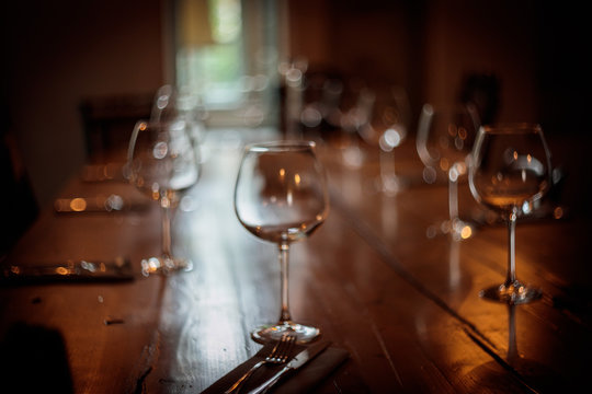 Restaurant industry related. Wine glasses on restaurant table,drink bottles and people sat at dining tables.