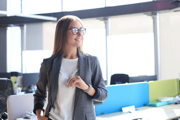 Attractive business woman smiling while standing in the office.