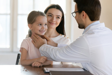 Male doctor do checkup consult cute little girl visiting with young mom in clinic, man pediatrician or physician examine small child at regular family consultation in hospital, healthcare concept