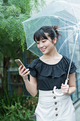女性　雨　散歩　スマホ