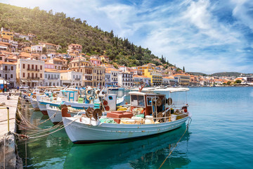 Blick auf den Ort von Gytheio, südliches Peloponnes, Griechenland, mit traditionellen Fischerbooten, Tavernen am Meer und Sonnenschein