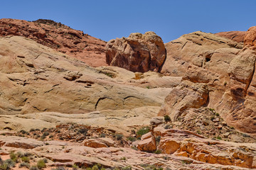 Large boulder dropped off with the last glacier sits atop sandstone formations in the Nevada Desert
