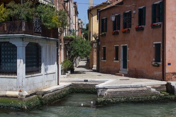 Fototapeta na wymiar VENICE, ITALY - MAY 28 2016: Narrow alley in Venice waterfront