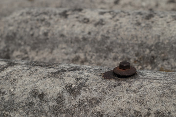 Old roofing tiles made of asbestos and cement. Dangerous and unhealthy roofing, visible old and rusty screw for fixing the tiles.