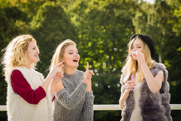 Women friends blowing soap bubbles.