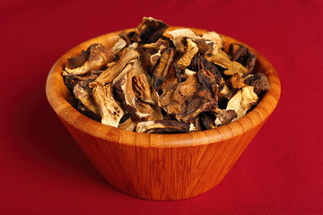 Dried mushrooms in wooden bowl. Boletus badius.