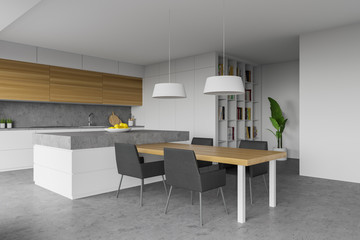 White kitchen with island, table and bookcase