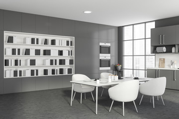 Gray kitchen corner with table and bookcase